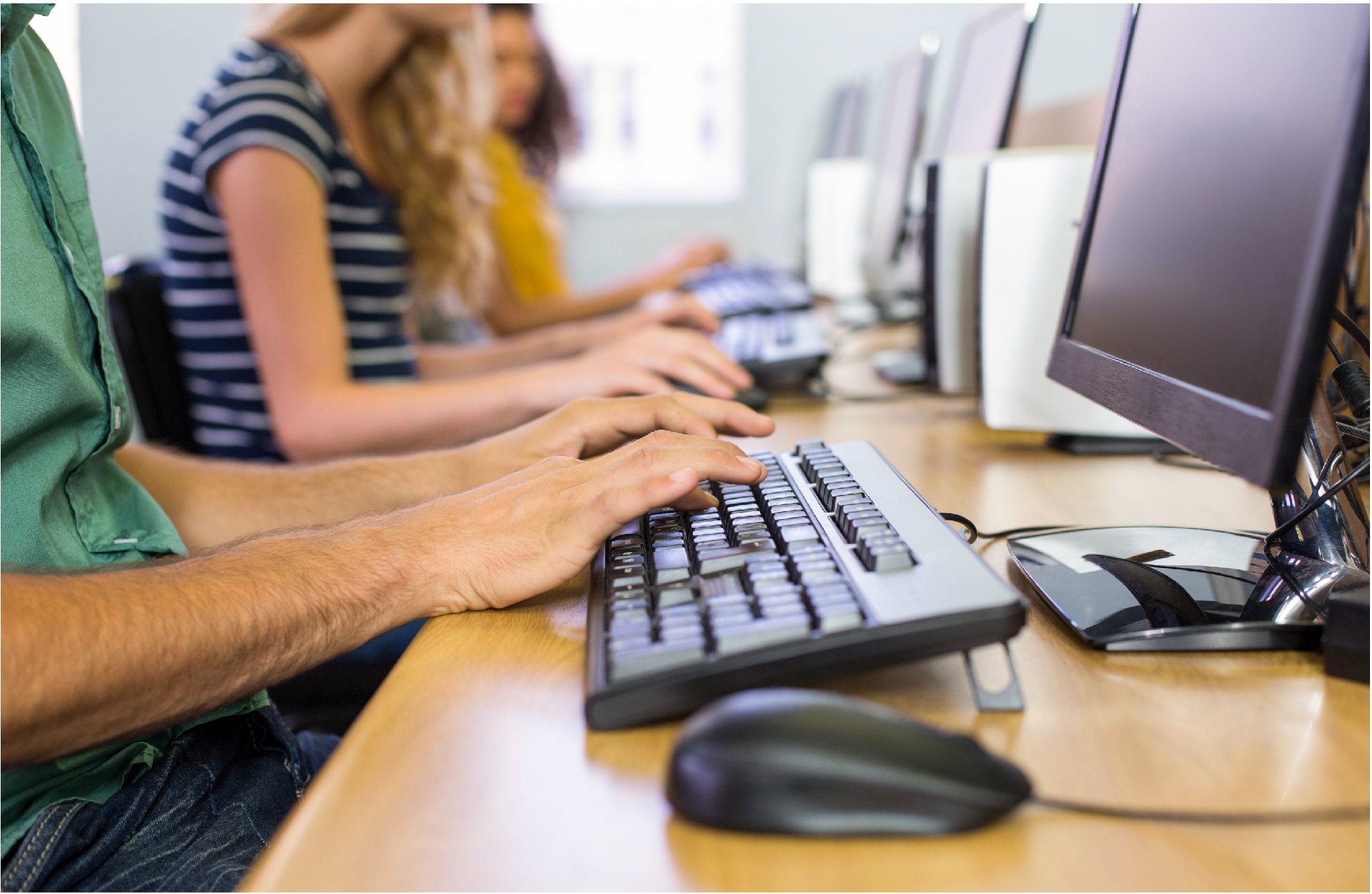 Hands typing on a computer keyboard in a lab setting