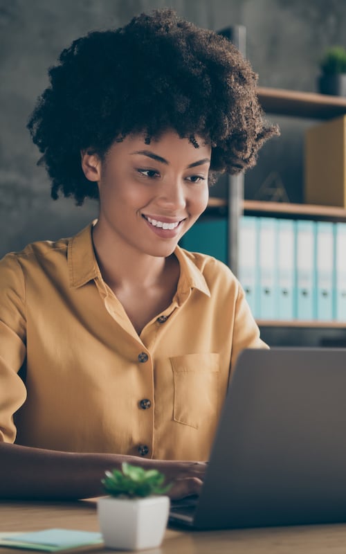 Female student smiling looking at laptop.
