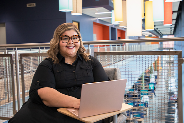 AlamoONLINE female student smiling with laptop open at Palo Alto College