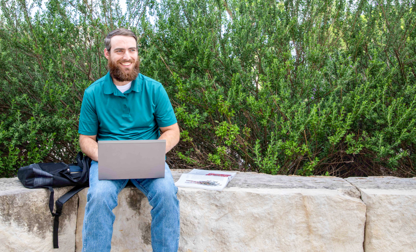 alamo college student working on laptop
