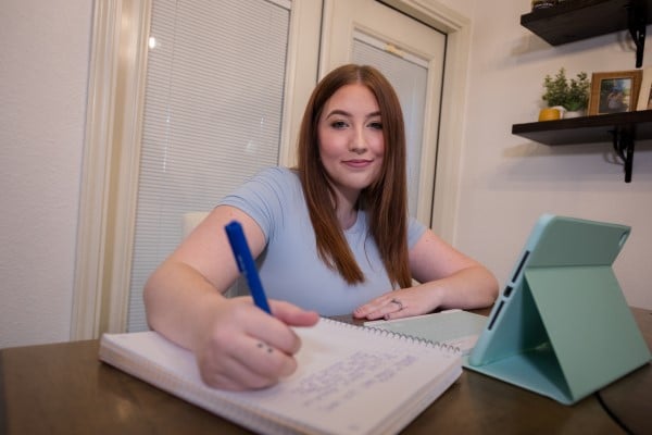 AlamoONLINE student Nicollete writing on notebook