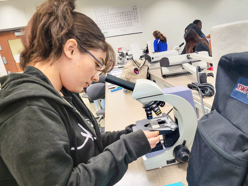female student in a lab with lab instruments