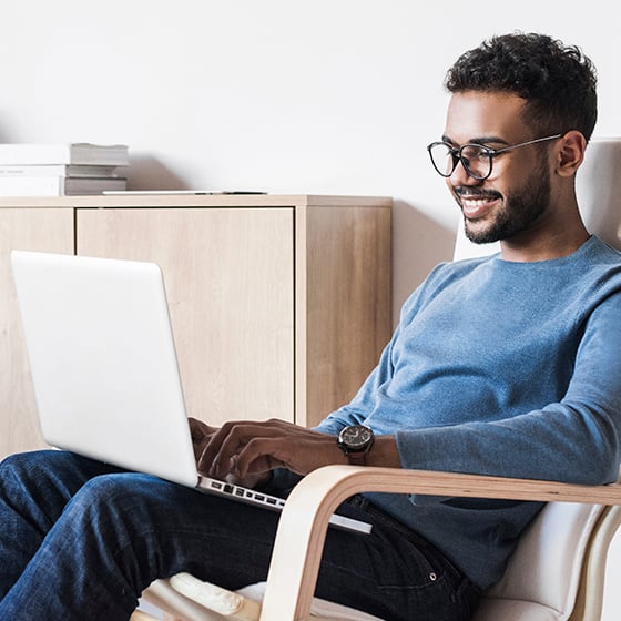 male student on his laptop smiling