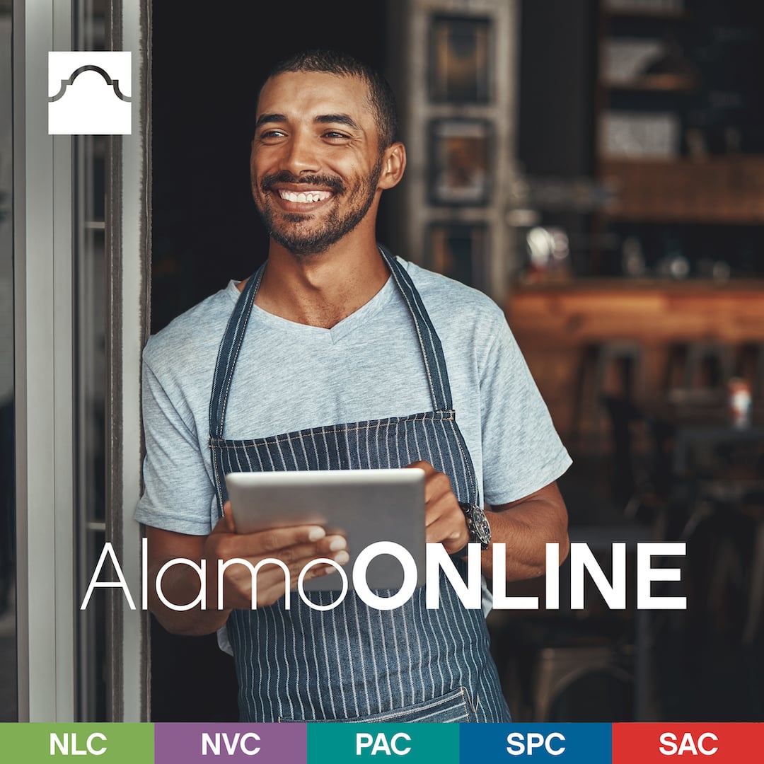 Male student smiling holding a tablet
