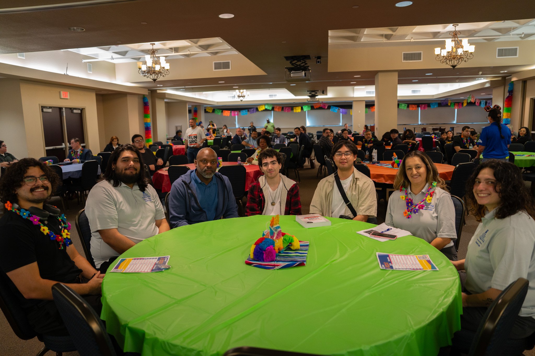 Group of four males and two female students sitting at a table