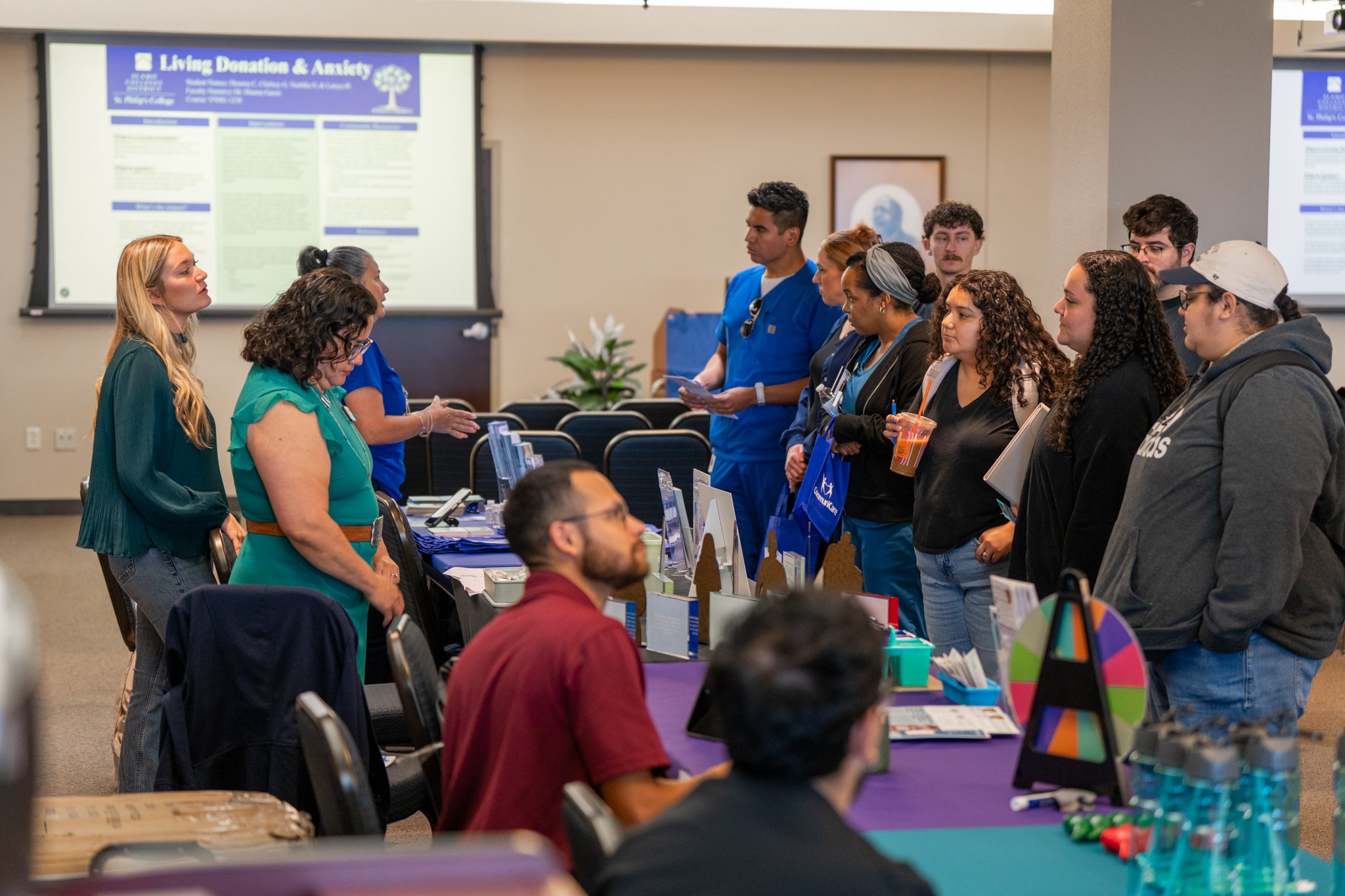 A row of tables is set up at Jessica&rsquo;s Project event space as students interact with vendors and review materials.