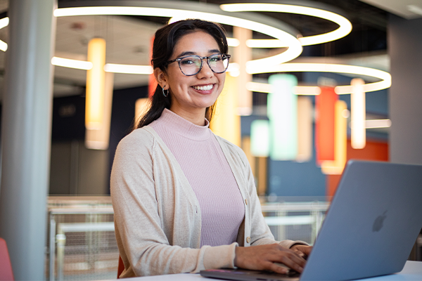 Photo of Araceli AlamoONLINE student smiling with her laptop open
