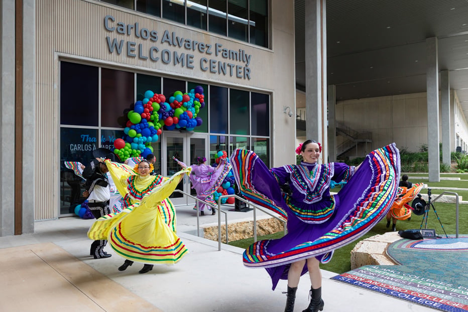 people dancing and twirling in front of building