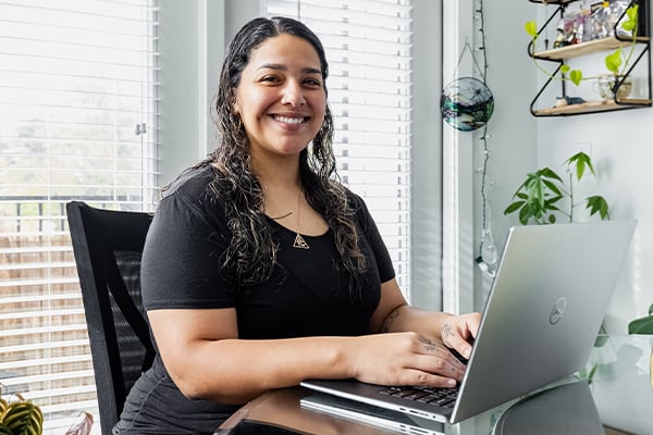 Kiera an online student at Alamo Colleges in her home with a laptop.