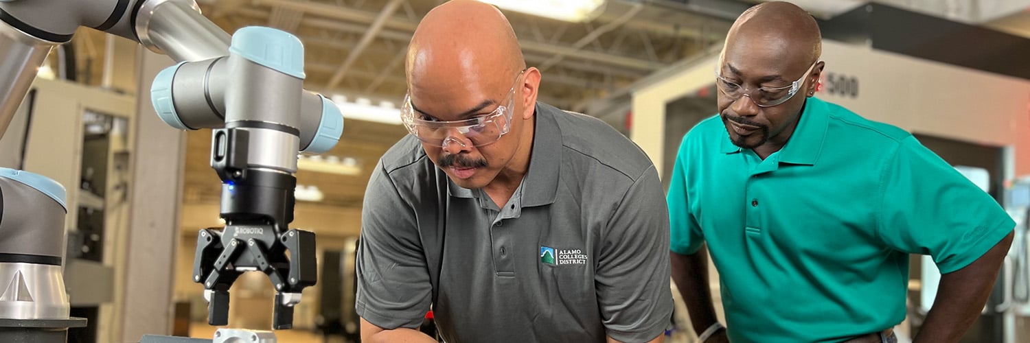 Two men operating a robotic arm