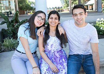 three students outdoors and smiling