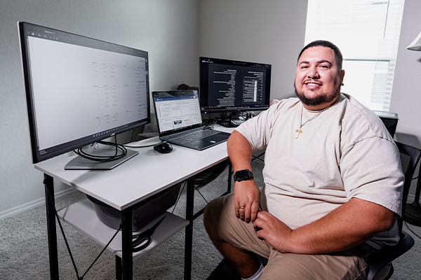Miguel an online student at Alamo College in his home office.
