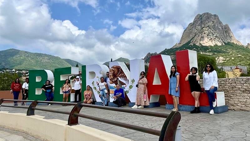 students posing in front of a large sign that reads: Bernal