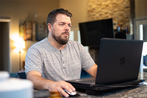 Johnathan on his laptop in his home.jpg