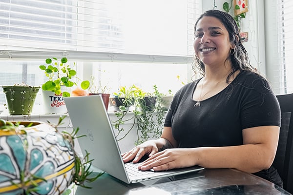 Kiera an online student at the Alamo Colleges on her laptop in her home