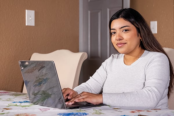 Mary an online student at the Alamo College on her laptop in her home