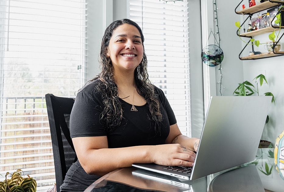 Alamo Colleges Online female student smiling with laptop open