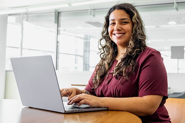 Kiera an online student at Alamo College with a laptop.