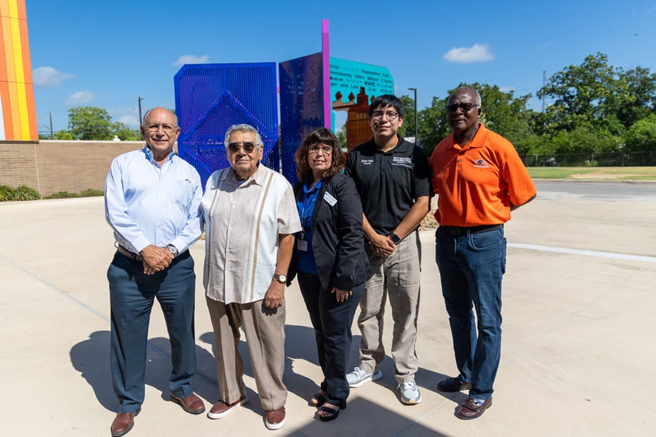 people standing in front of artwork unveiling