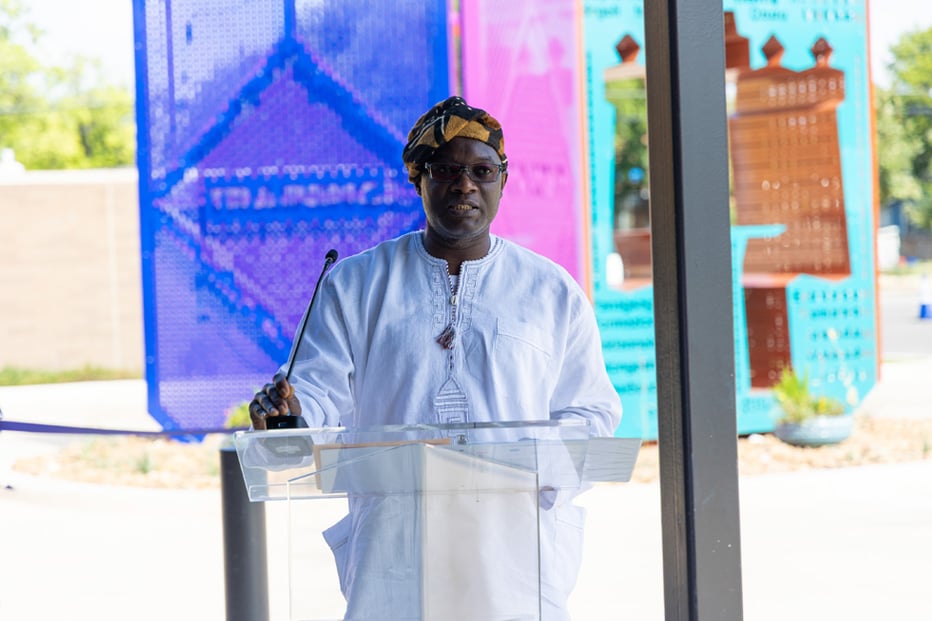 Akirash speaking in front of artwork