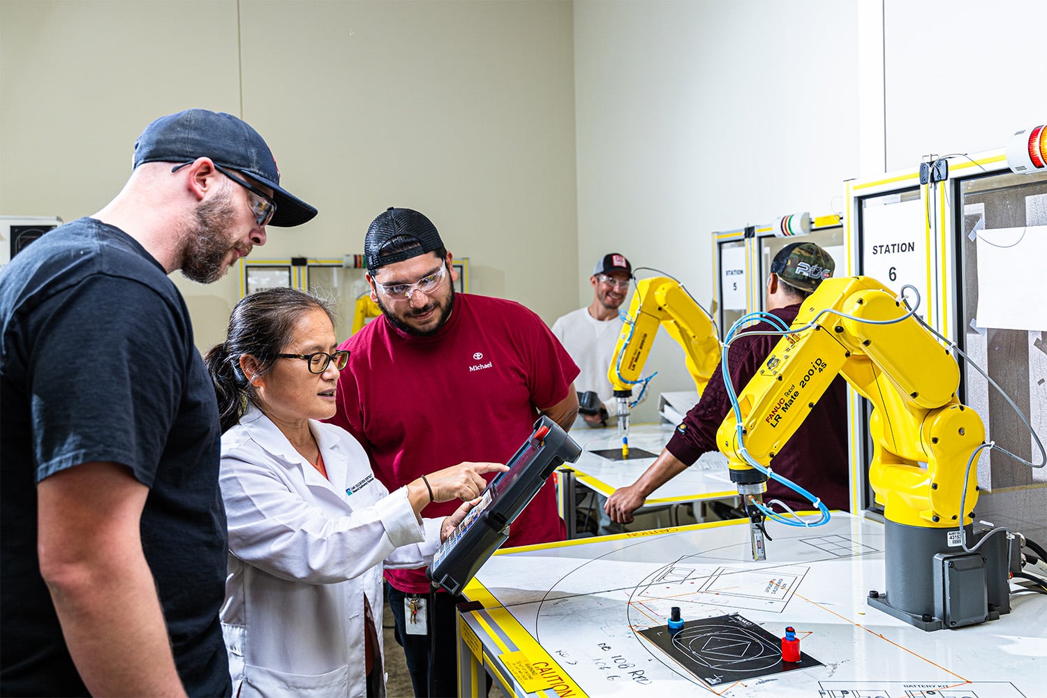 two men learning advanced manufacturing from female teacher