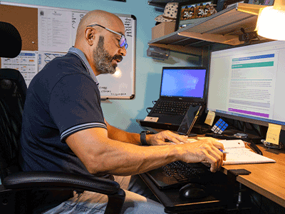 Roger sitting at his computer desk.png