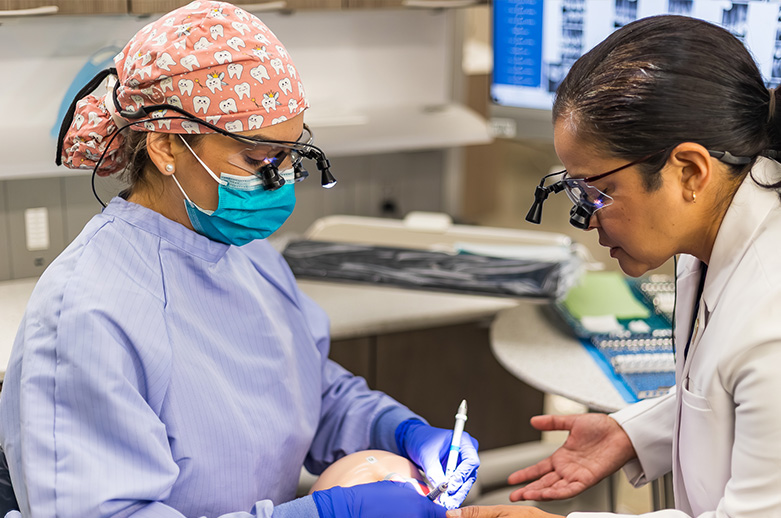 Photo: Student Alma Navarro (left) and instructor Mel Treviño (right) practicing a teeth cleaning.