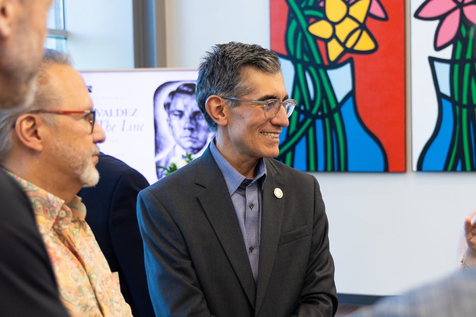 Dr. Flores speaking to patrons in art gallery