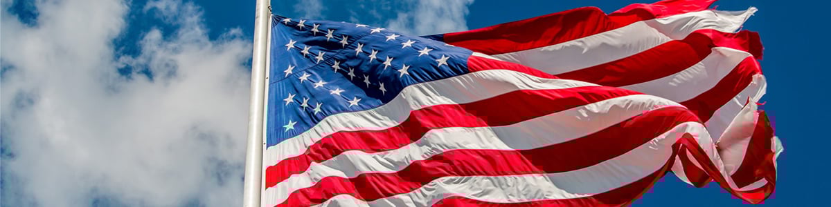 Veterans Affairs Center located at the colleges United States Flag waving in front of a clear, blue sky