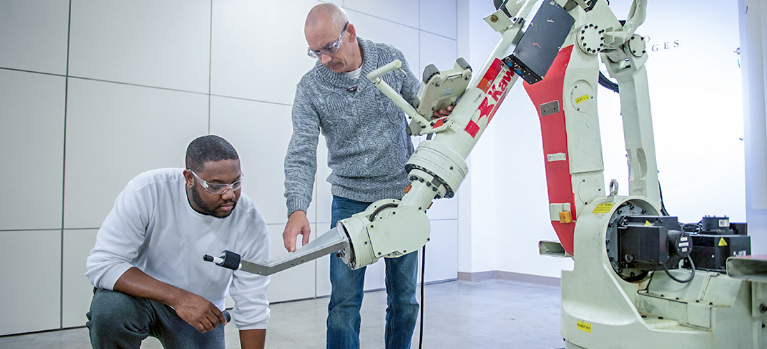 Student and instructor examining robotic arm