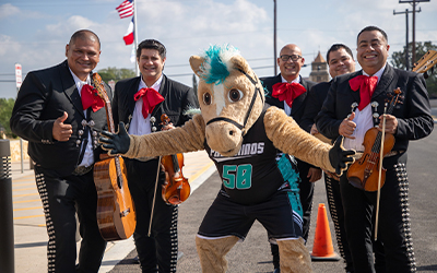 The Palo Alto College Palomino mascot poses with mariachis
